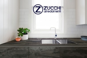 Cucina con Piano di lavoro Dekton® Radium riproduce l’effetto di una lastra d'acciaio arrugginita e acidamente degradata, un'estetica che combina l'espressione calda di toni arancio e marroni con tonalità blu-verdognole. Produzione sostenibile,